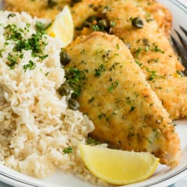 Lemon rice pilaf and chicken piccata on a platter.