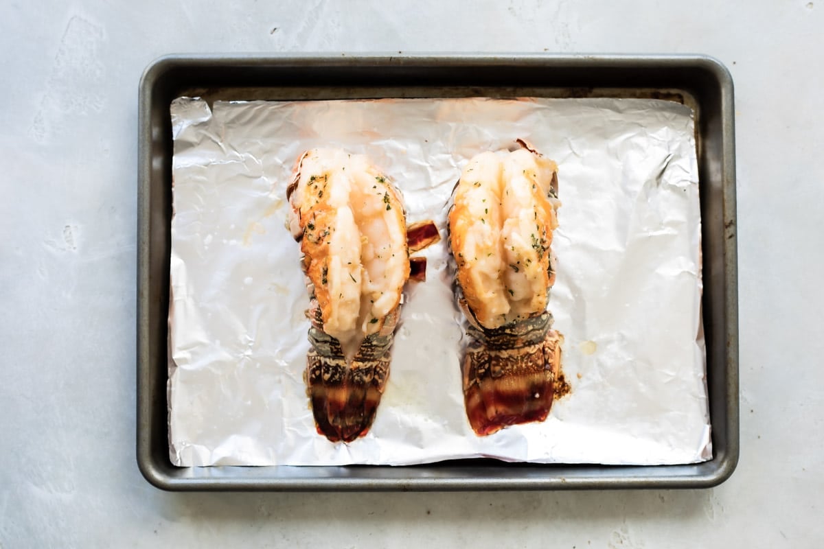 Roasted lobster tails ona. baking sheet.