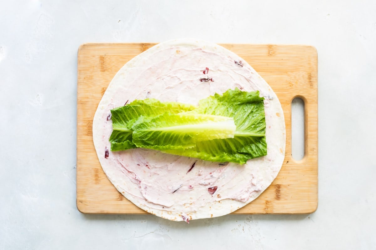 A tortilla with lettuce on top.