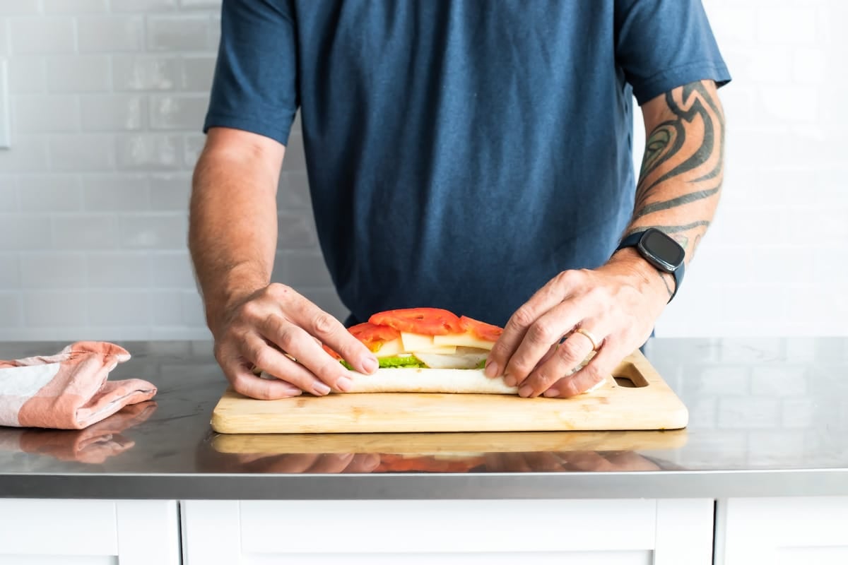 Rolling a turkey roll up.