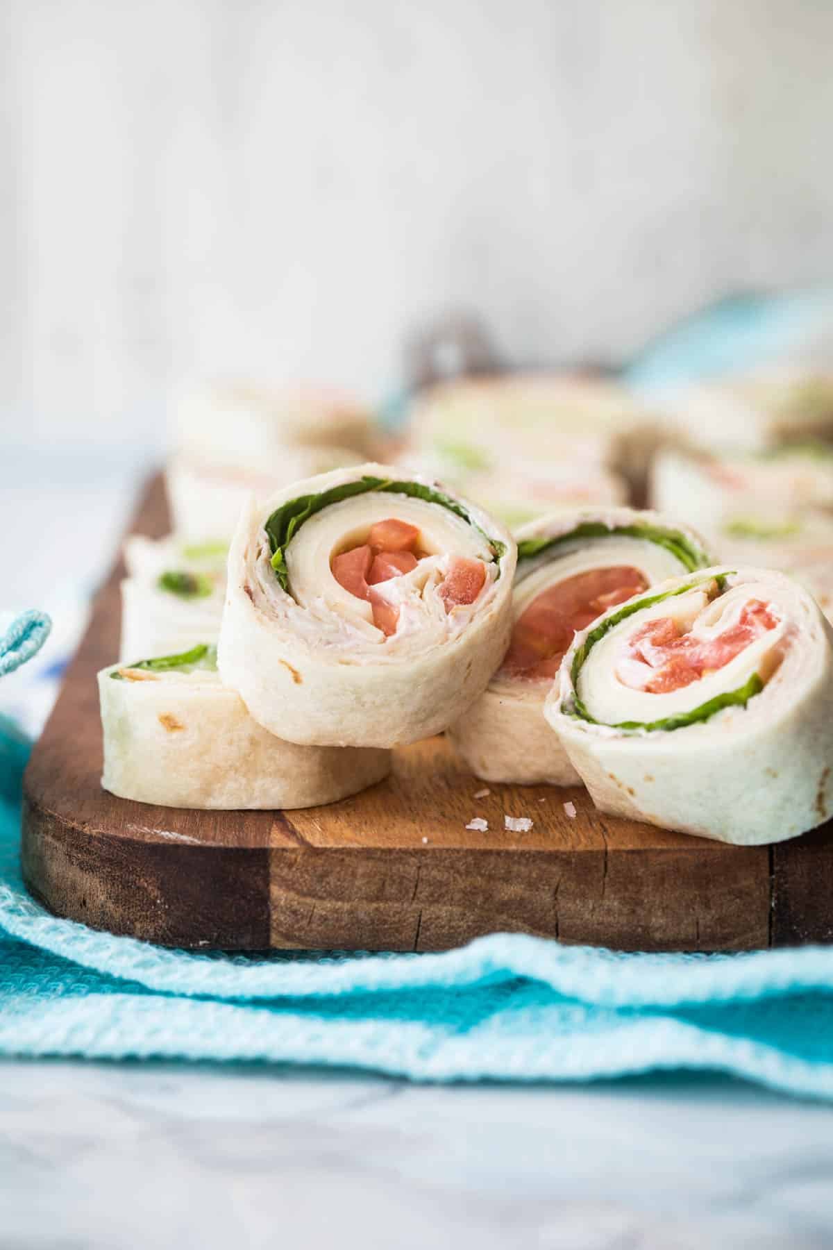Slices of turkey roll ups on a wooden board.