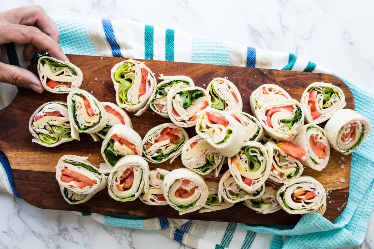 Slices of turkey roll ups on a wooden board.