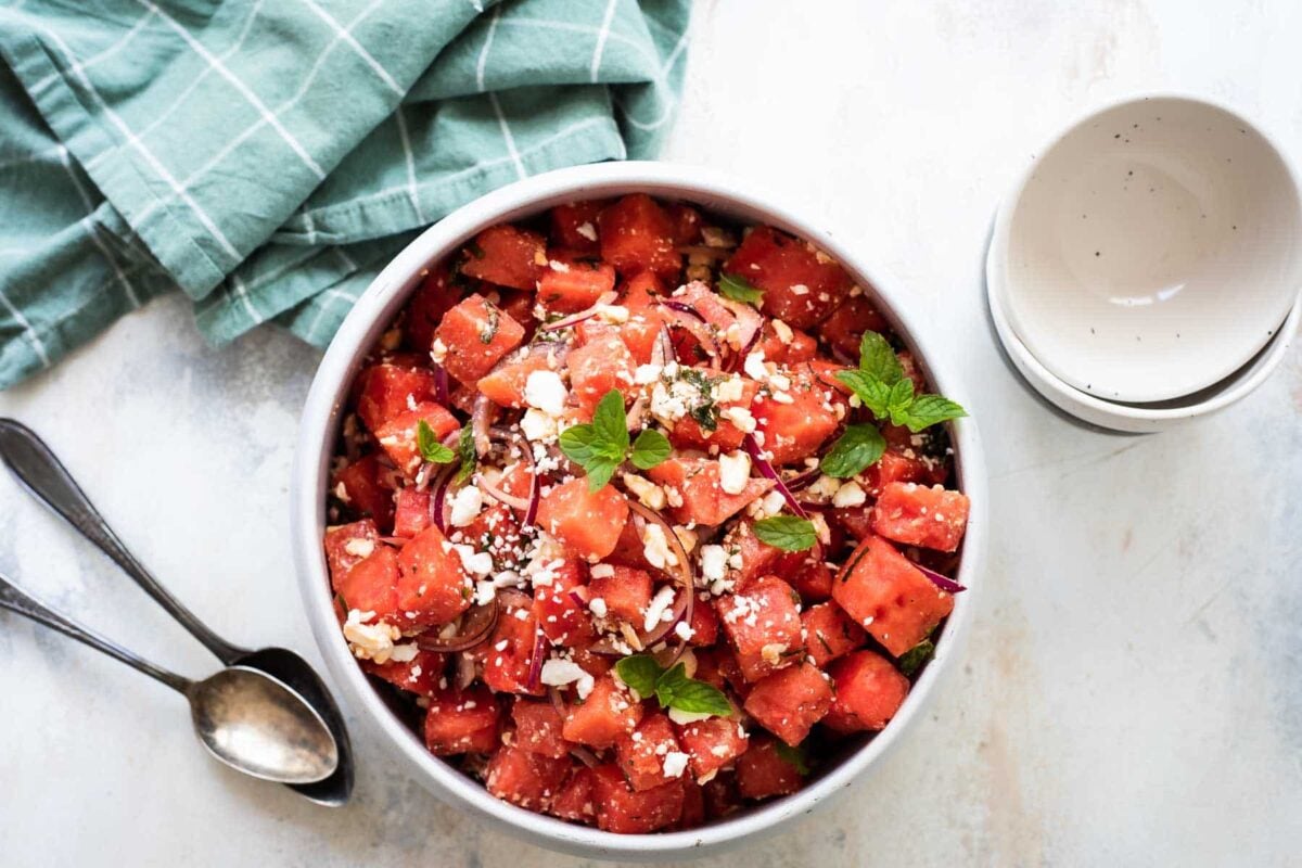 A marble serving bowl filled with Watermelon Salad.