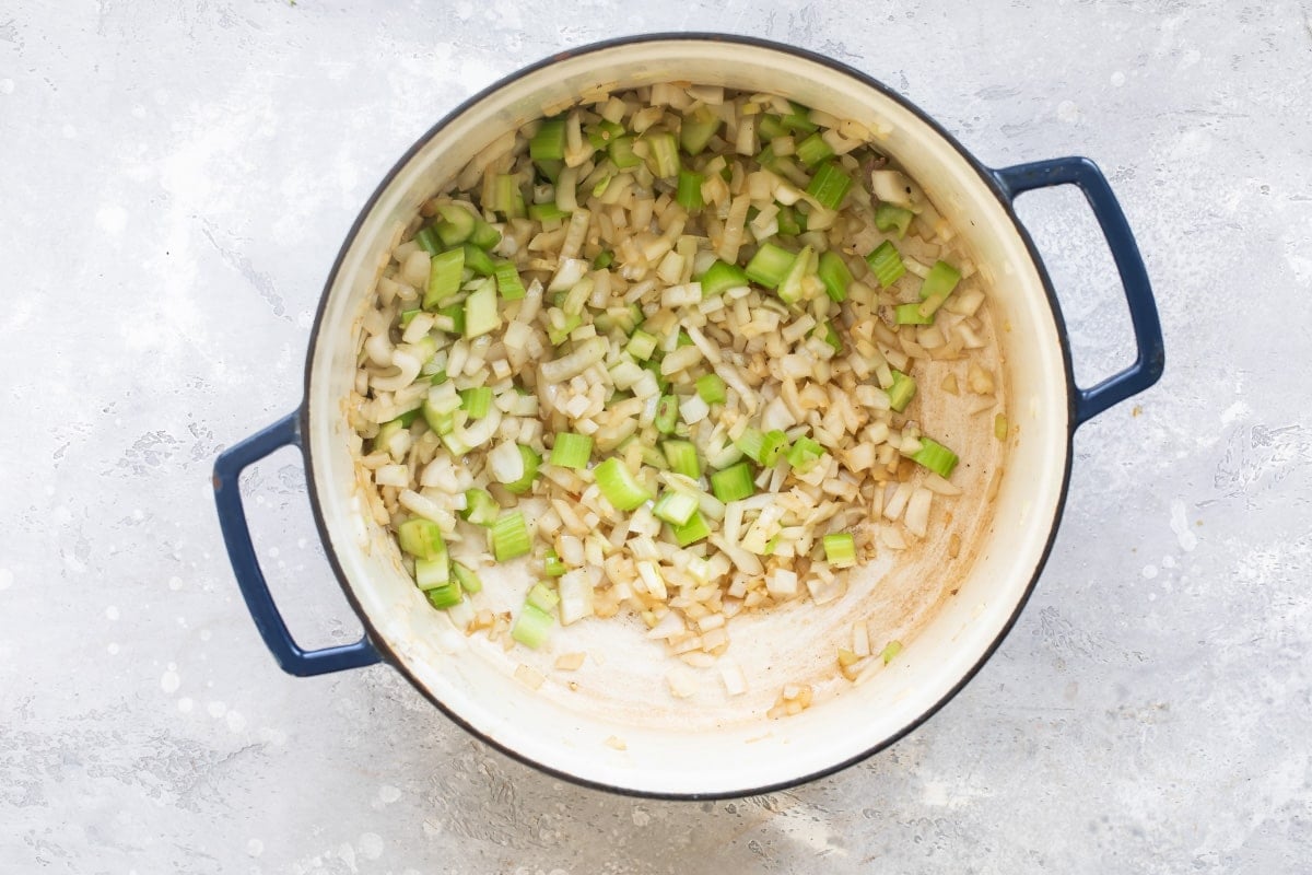Celery and onions cooking in a pot.