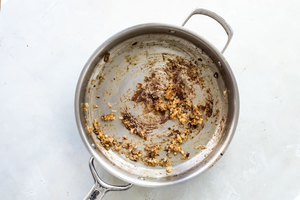 Cooking shallots in a skillet of oil.