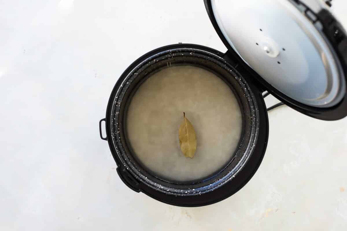 A rice cooker of uncooked rice and water.
