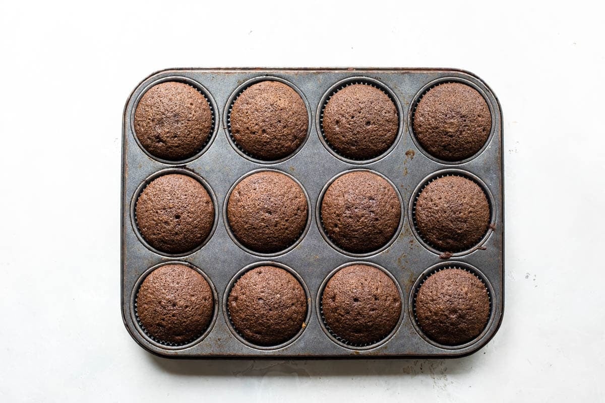 A muffin tin full of chocolate cupcakes.