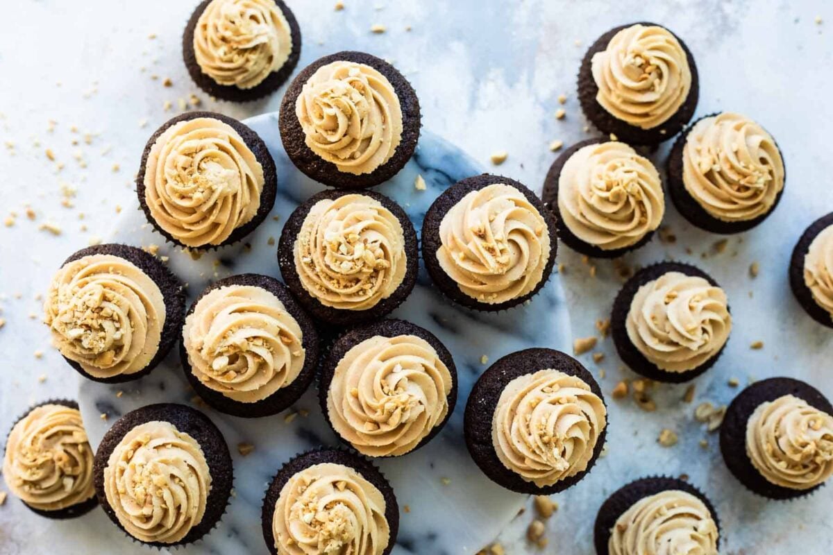 A cake stand filled with chocolate cupcakes with peanut butter frosting.