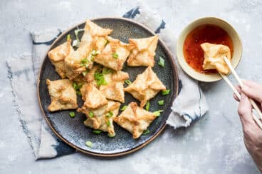 Cream cheese wontons on a blue plate.
