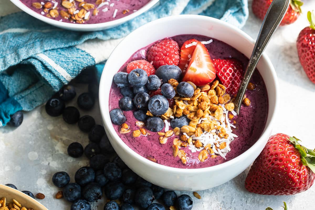An easy acai bowl topped with coconut, nuts, and berries.