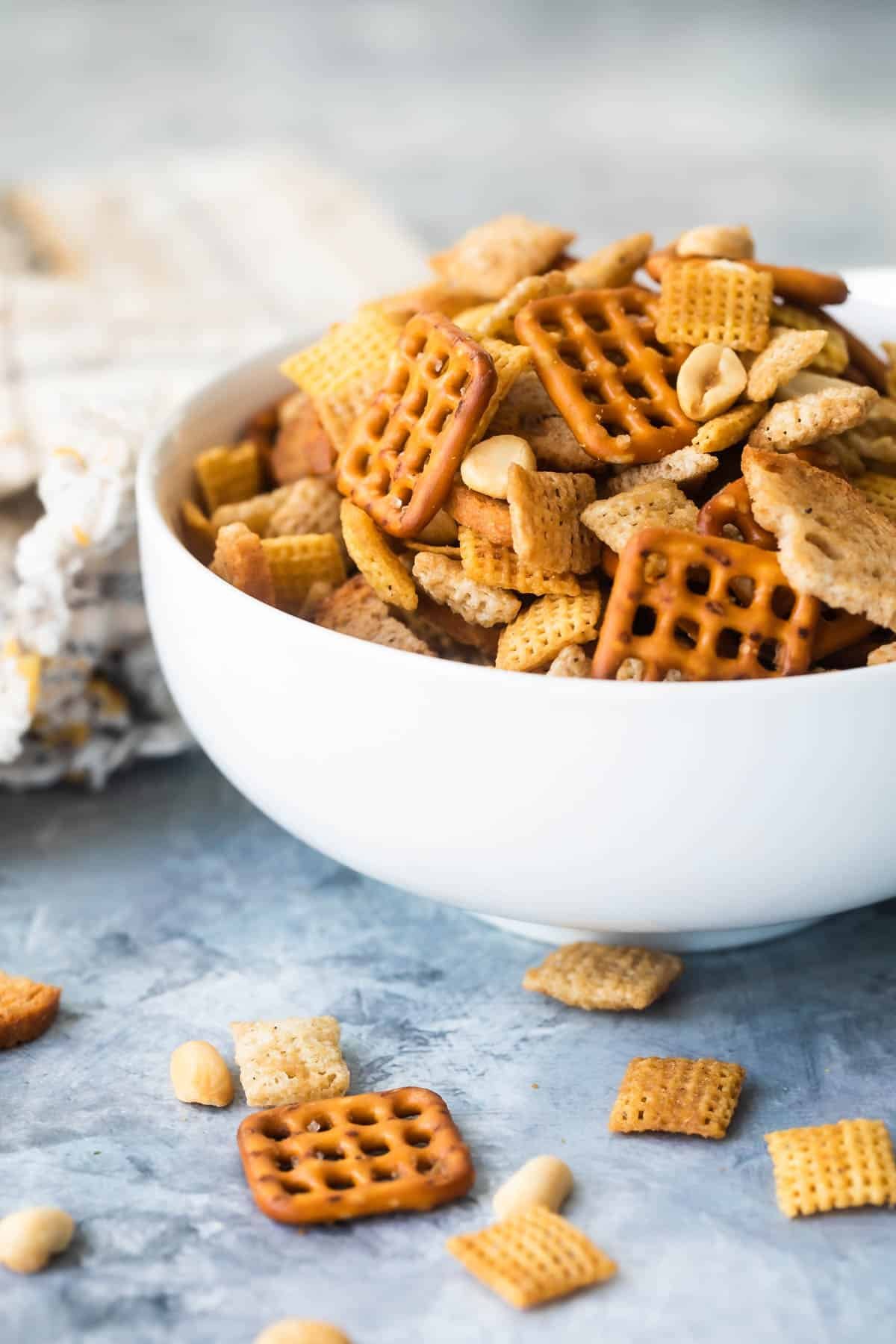 A bowl of Chex mix on a gray background.