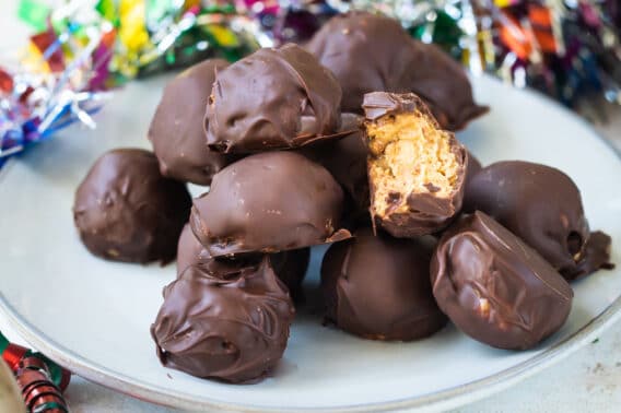 No bake peanut butter balls on a white plate.