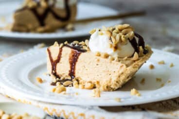 Two slices of peanut butter pie on white plates.