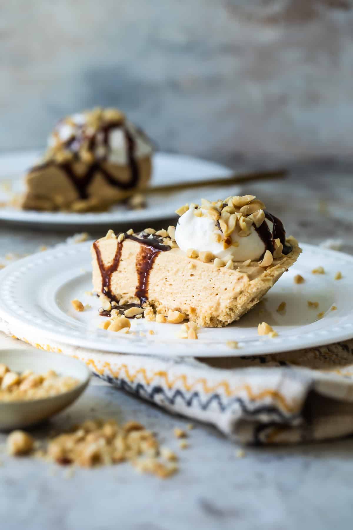 Two slices of peanut butter pie on white plates.