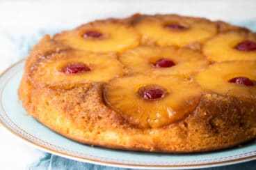 A pineapple upside down cake on a light blue platter.