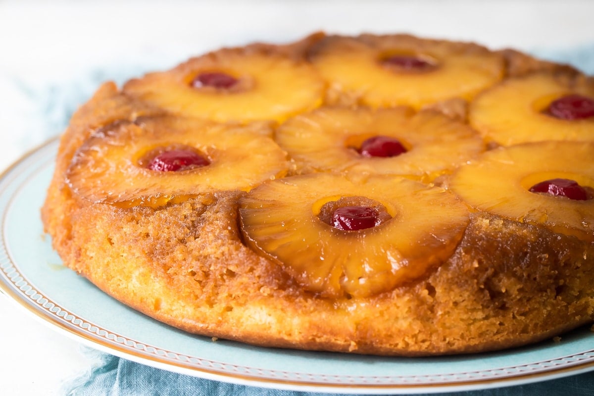 A pineapple upside down cake on a light blue platter.