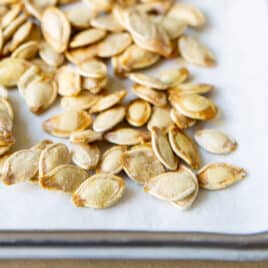 Roasted pumpkin seeds on a baking sheet.