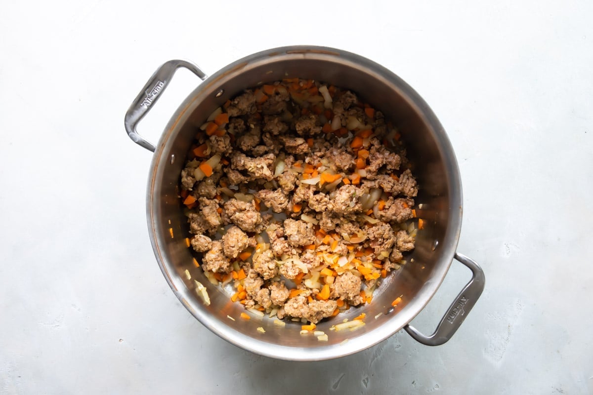 Browning Italian sausage in a saucepan.