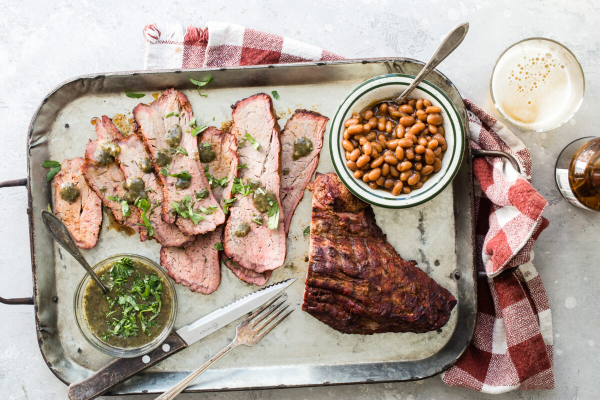An overhead shot of slices of smoked tri tip on a sliver tray.