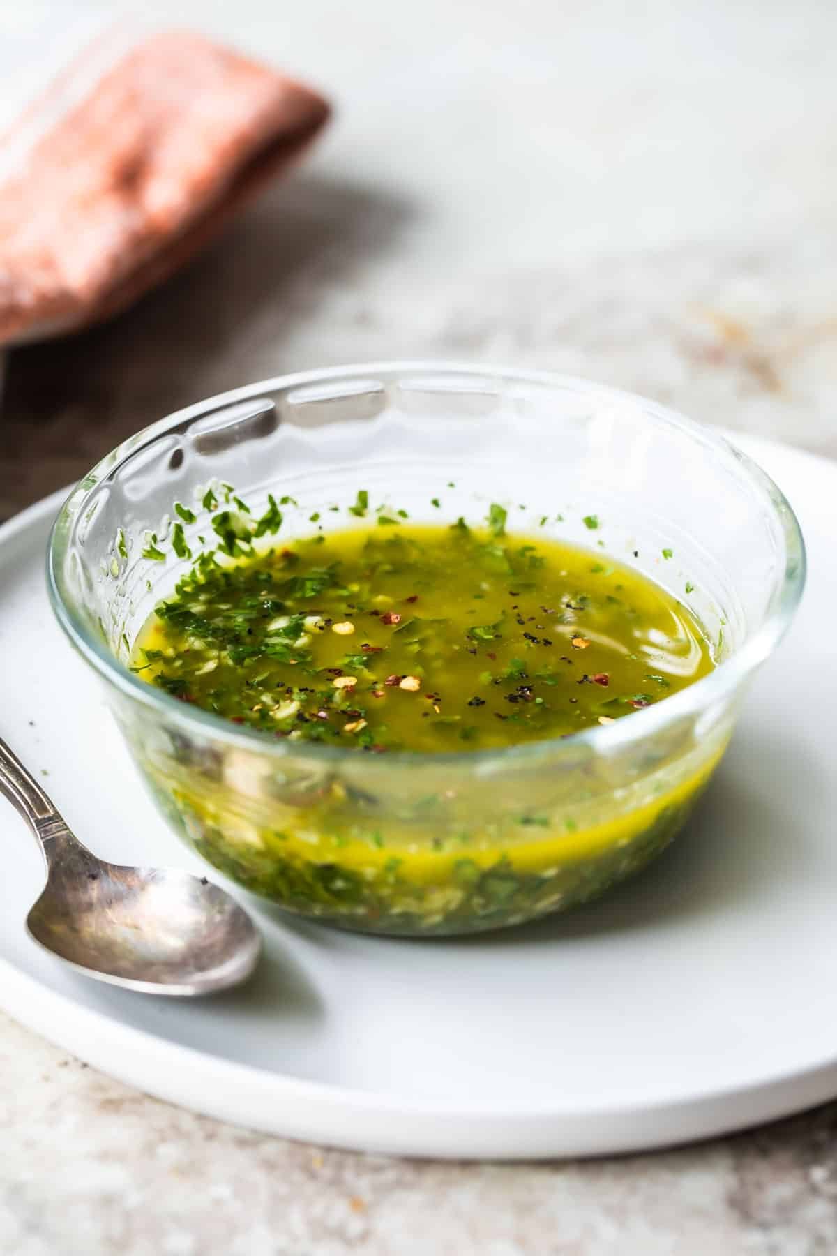 Chimichurri sauce in a small clear glass bowl.
