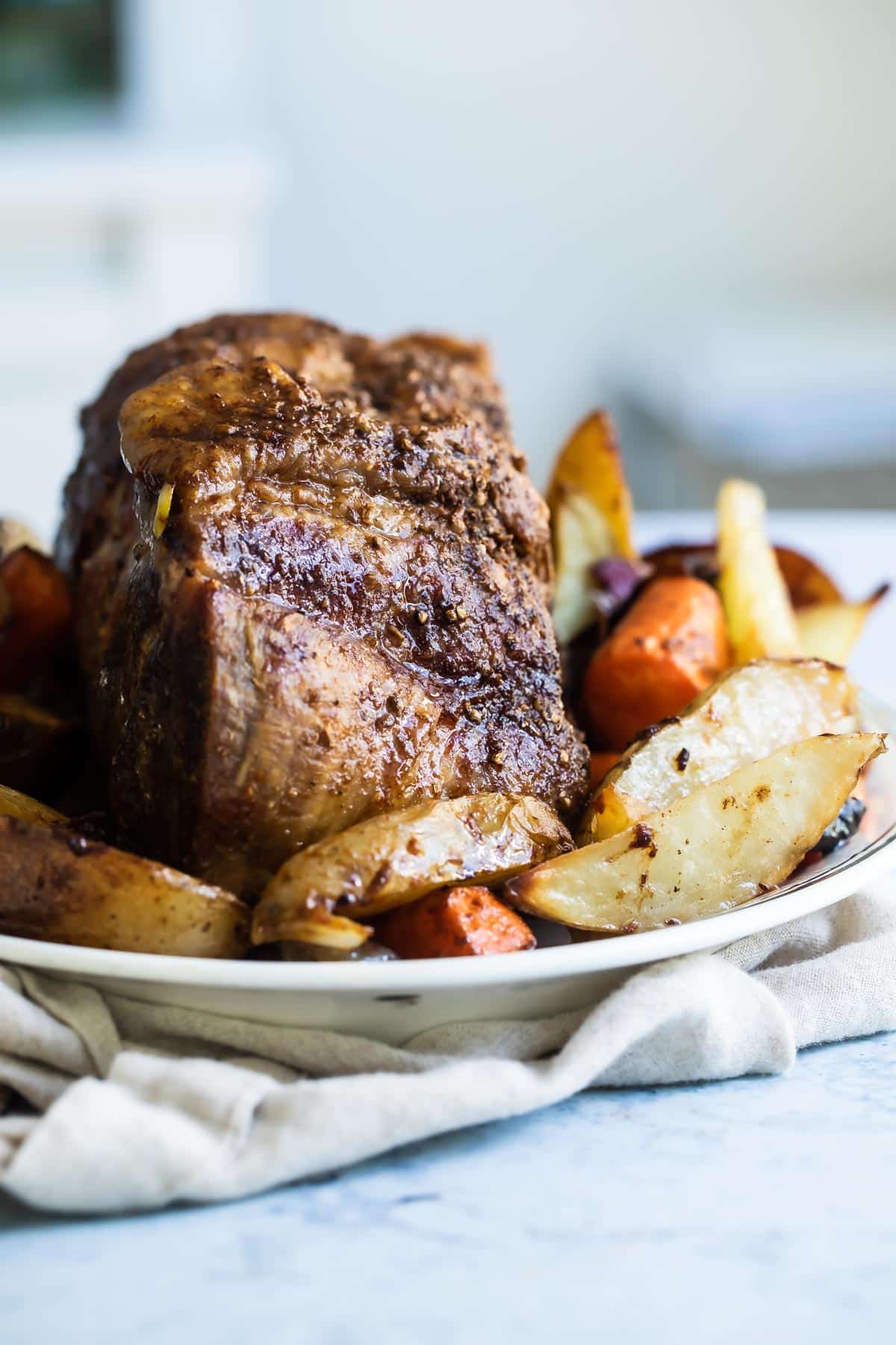 A platter with pork roast and vegetables.