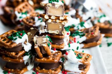 Rolo pretzel candies on a tray with Christmas sprinkles.