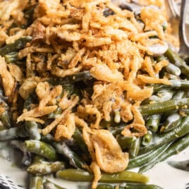Slow cooker green bean casserole on a patterned platter.