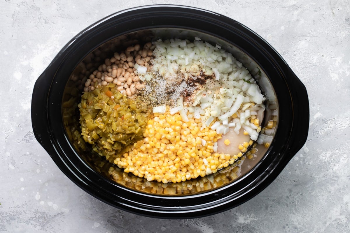 White chicken chili ingredients in a slow cooker before being cooked.