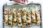 A baking sheet full of stuffed zucchini.