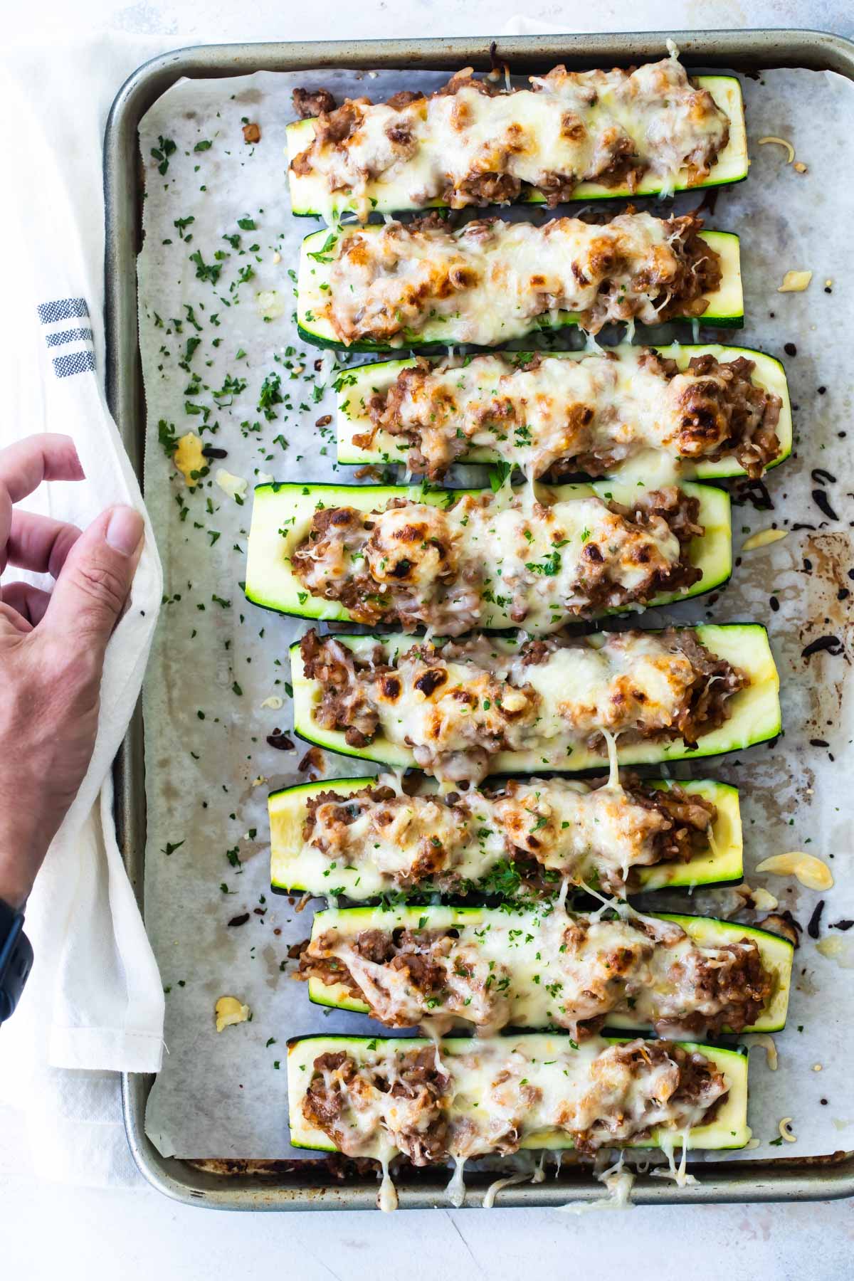 A baking sheet full of stuffed zucchini.