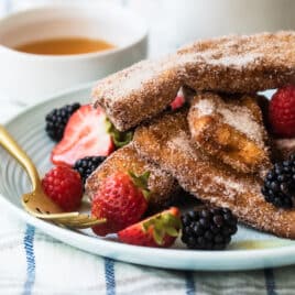 French Toast Sticks on a plate garnished with berries.