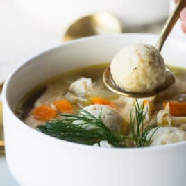 Someone scooping a Matzo ball out of a ball of Matzo ball soup.