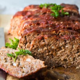 Meatloaf slices on a wooden cutting board.