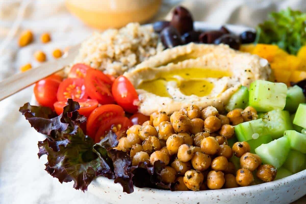 A Mediterranean Buddha bowl next to a small bowl of roasted chickpeas.