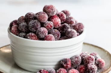 Sugared cranberries in a small white bowl.