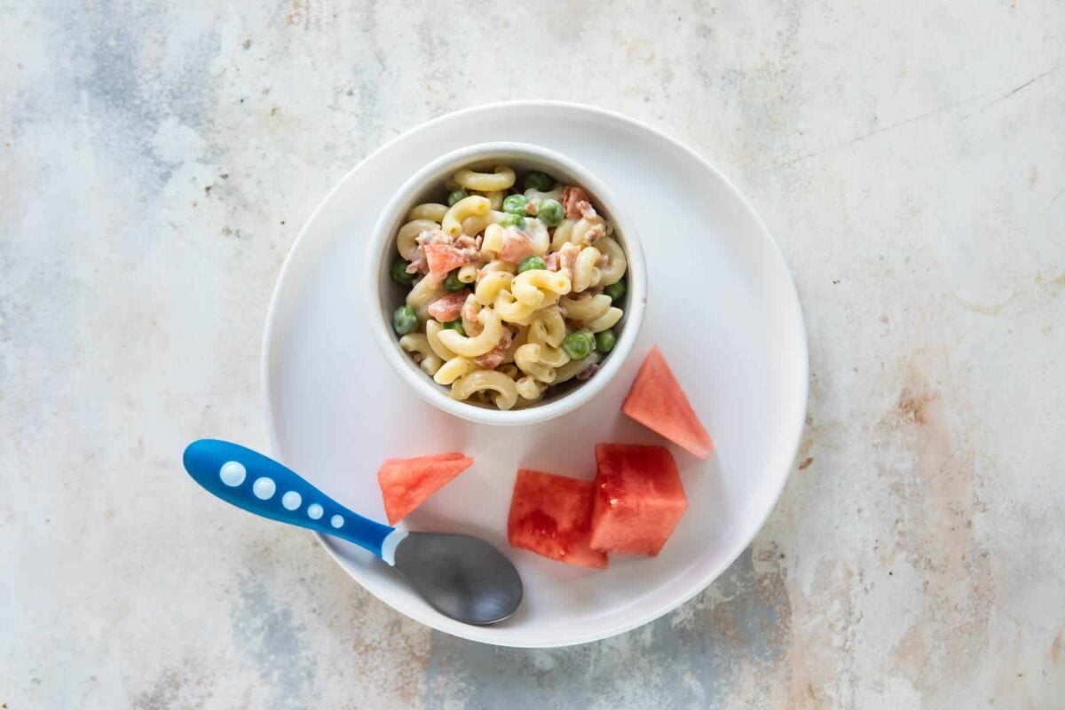 A toddler lunch of pasta salad and watermelon.