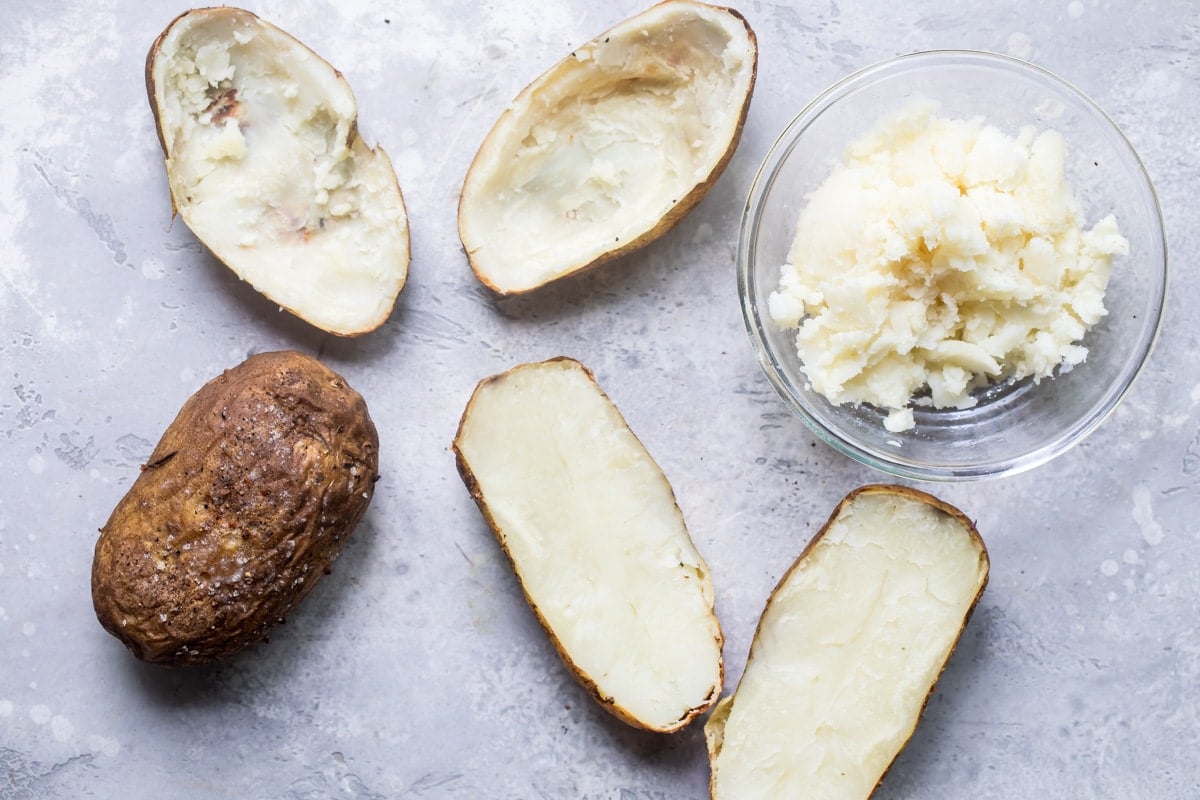 Halved potatoes with some of the insides removed.