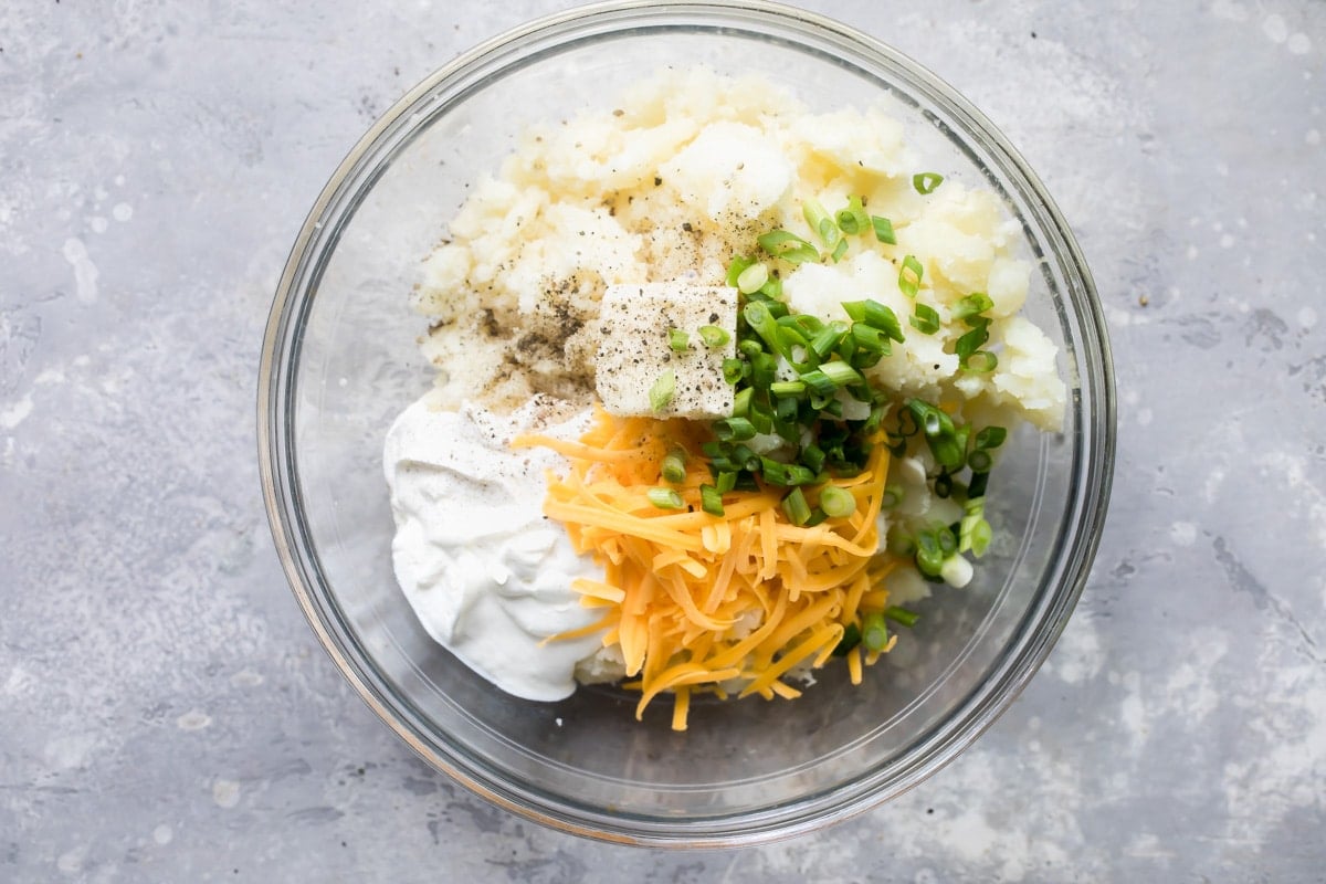Twice baked potato filling in a clear glass bowl.