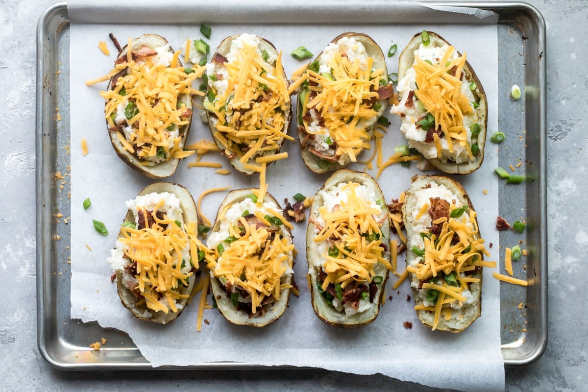 Twice baked potatoes on a baking sheet before being baked a second time.