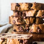 Thick slices of chocolate chip banana bread on a wooden cutting board.