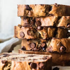 Thick slices of chocolate chip banana bread on a wooden cutting board.