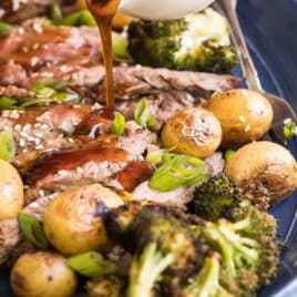 A platter of Hibachi Steak with Grilled Wasabi potatoes and teriyaki sauce being drizzled over it.