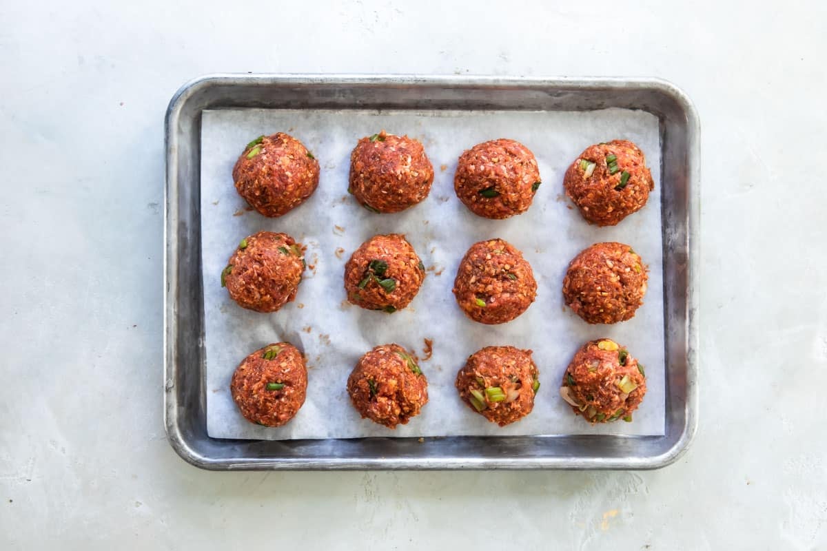 Koreran barbecue meatballs on a baking sheet before being baked.