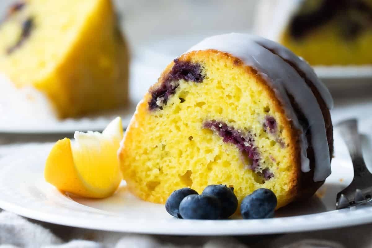 Slices of Lemon Blueberry Cake on white plates.