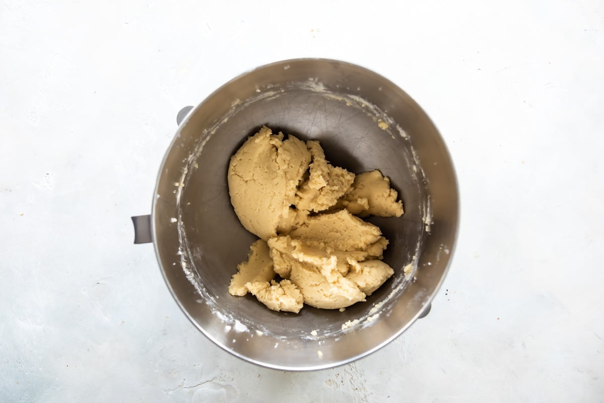 Linzer cookie dough in a silver mixing bowl.