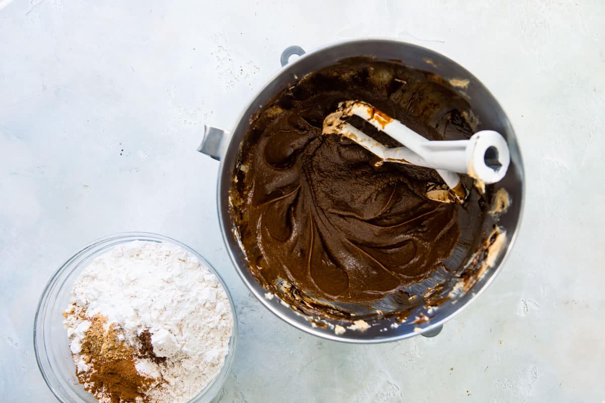 Molasses cookie dough wet ingredients after being mixed in a silver mixing bowl.