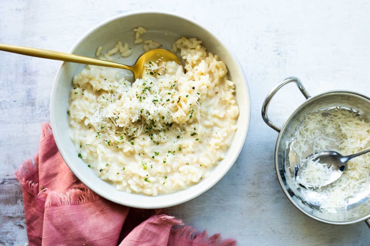 A serving bowl full of Risotto garnished with parsley.