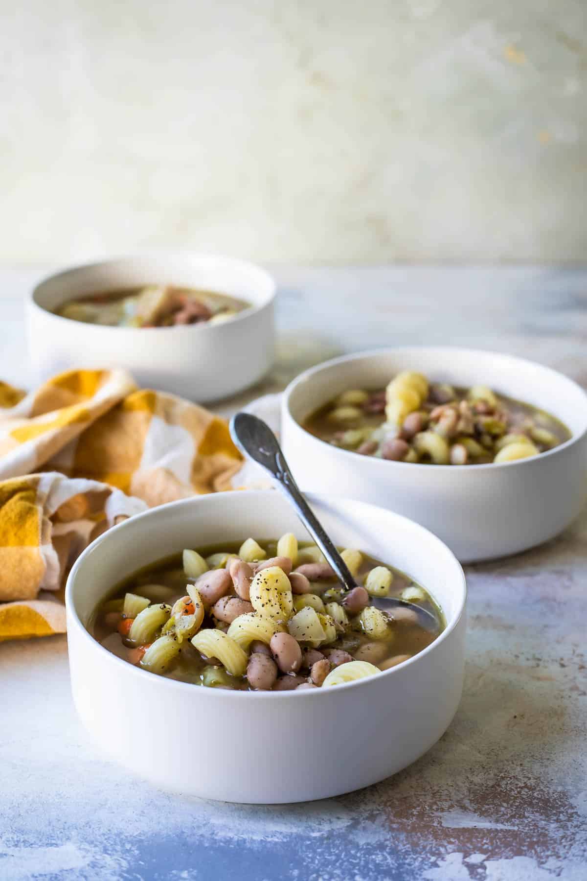 Three bowls of slow cooker pasta and bean soup.