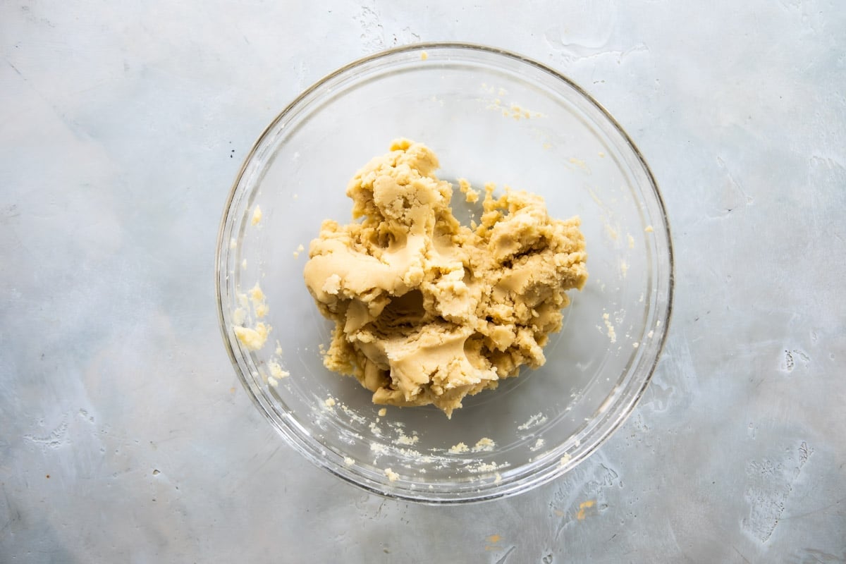 Spritz cookie dough in a clear glass bowl.