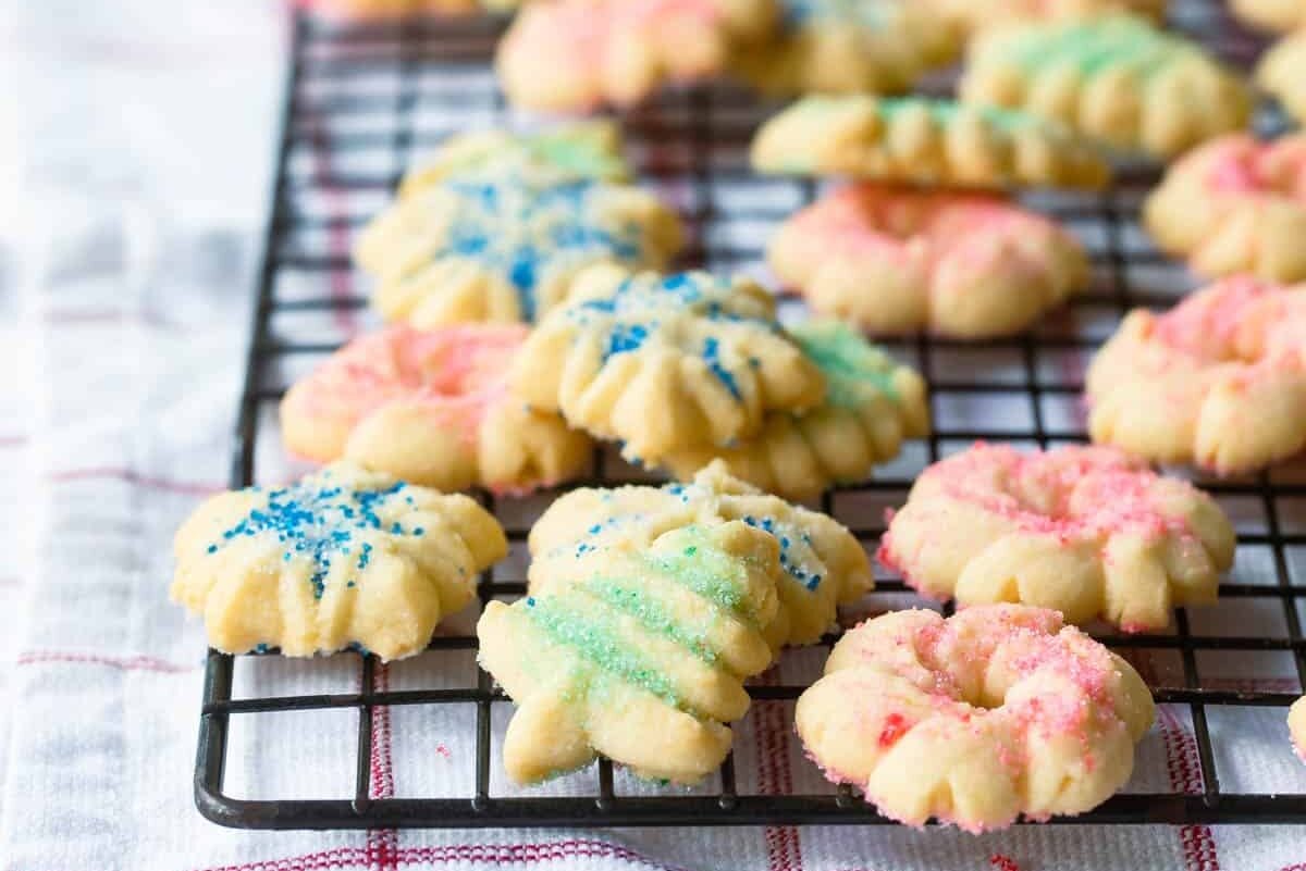 Spritz cookies on a metal cooling rack.